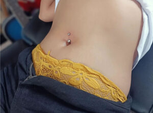 Woman client with her new navel piercing from Irie Pierching Siargao studio.